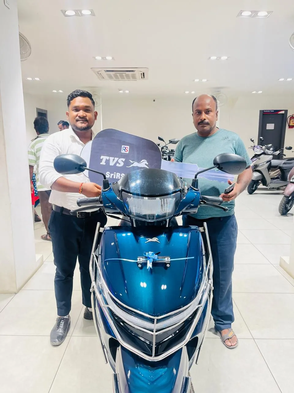 Customer taking delivery of a TVS Jupiter